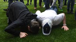 Suporter mencium rumput usai laga Tottenham melawan Manchester United di stadion White Hart Lane, London, (14/05/2017). Laga tersebut merupakan laga terakhir di White Hart Lane setelah 118 tahun menempati stadion tersebut. (EPA/Facundo Arrizabalaga