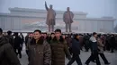 Penduduk Pyongyang usai memberi hormat untuk patung pemimpin Korea Utara Kim Il Sung dan Kim Jong Il selama Hari Peringatan Nasional di Bukit Mansu, Pyongyang (17/12).  Korea Utara tengah memperingati 7 tahun wafatnya  Kim Jong Il. (AFP Photo/Kim Won Jin)