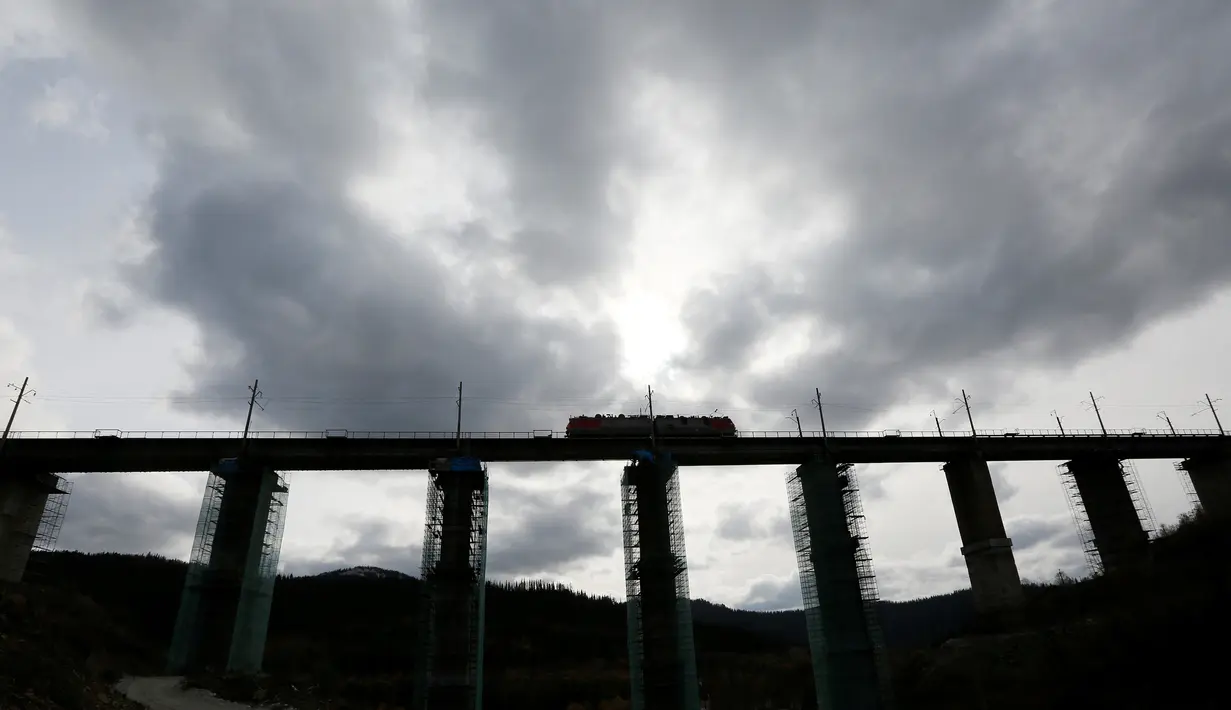 Lokomotif melintas di jembatan kereta yang dalam proses penyelesaian di Taiga, dekat stasiun Dzheb, Krasnoyarsk, 10 Oktober 2016. Rusia membangun jembatan kereta tertinggi di negaranya yang merupakan proyek Trans-Siberian Railway (REUTERS/Ilya Naymushin)