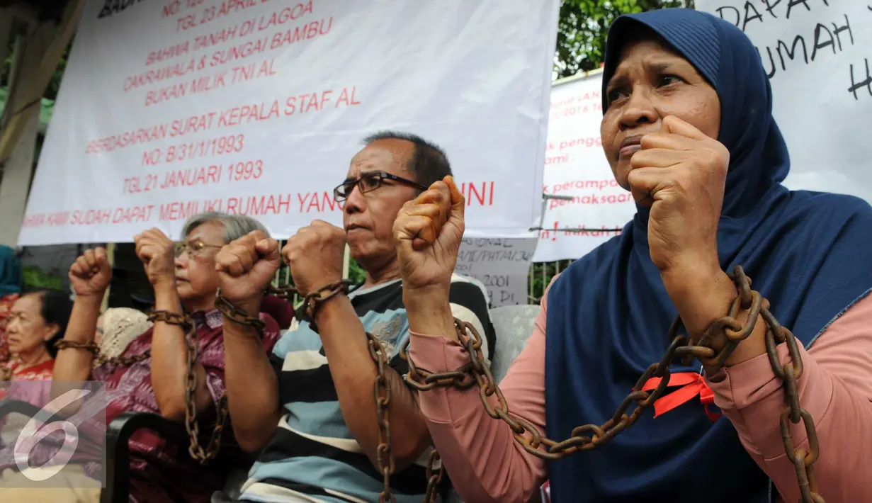 Sejumlah warga para sesepuh veteran mengikat tangannya dengan rantai di kawasan sungai bambu, Jakarta Utara, Rabu (3/2). Dalam aksi mereka menolak pengosongan rumah negara secara paksa terhadap 6 rumah negara. (Liputan6.com/Helmi Afandi)