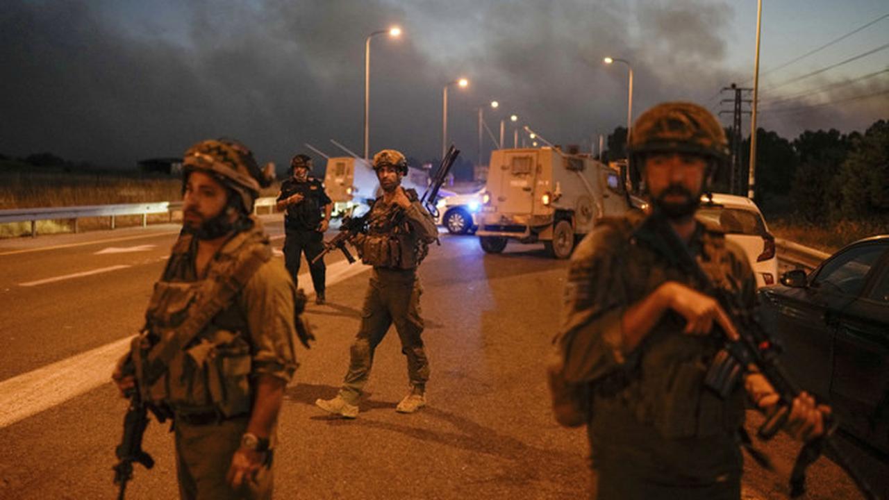 Tentara Israel memblokir jalan dengan latar belakang asap kebakaran setelah roket bombardir Hizbullah Lebanon menghantam Dataran Tinggi Golan yang dianeksasi Israel, Selasa, 9 Juli 2024. (AP)