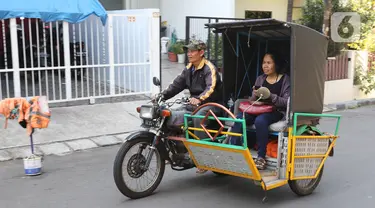 Penumpang menaiki ojek becak motor di salah satu perumahan di kawasan Meruya, Jakarta, Selasa (19/11/2019). Pesatnya perkembangan teknologi transportasi seperti ojek berbasis aplikasi, mengakibatkan keberadaan becak motor di Ibukota hampir punah. (Liputan6.com/Herman Zakharia)