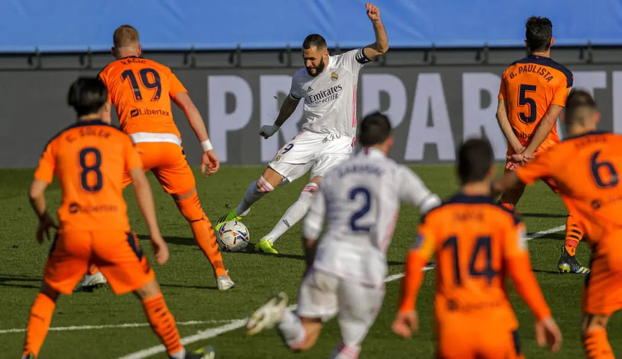Striker Real Madrid, Karim Benzema, melepaskan tendangan saat melawan Valencia pada laga Liga Spanyol di Stadion Alfredo Di Stefano, Minggu (14/2/2021). Real Madrid menang dengan skor 2-0. (AP/Manu Fernandez)