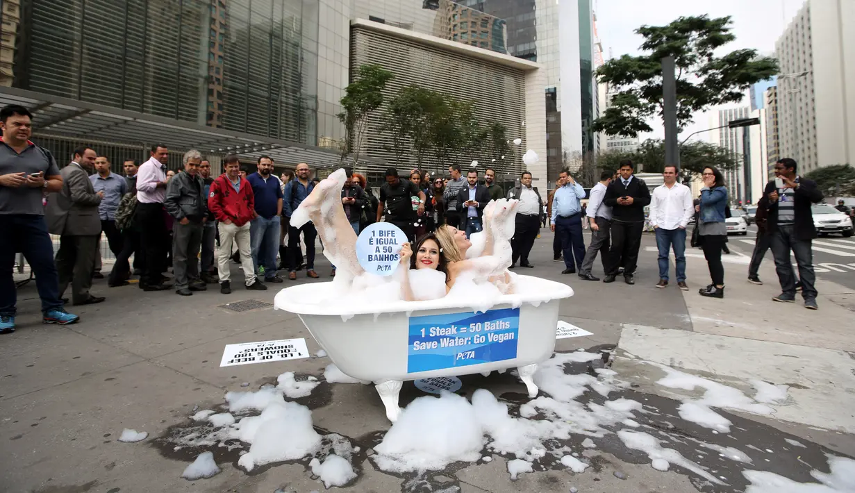 Dua aktivis wanita dari People for the Ethical Treatment of Animals (PETA) melakukan kampanye dengan mandi di Jalan Paulista di Sao Paulo, Brasil, Selasa (2/8). Aksi itu untuk mengajak masyarakat beralih ke pola makan vegetarian. (REUTERS/Paulo Whitaker)