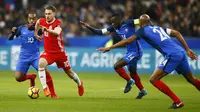 Gelandang Wales, Aaron Ramsey, berusaha melewati pemain Prancis pada laga persahabatan di Stadion Stade de France, Sabtu (11/11/2017). Prancis menang 2-0 atas Wales. (AP/Francois Mori)