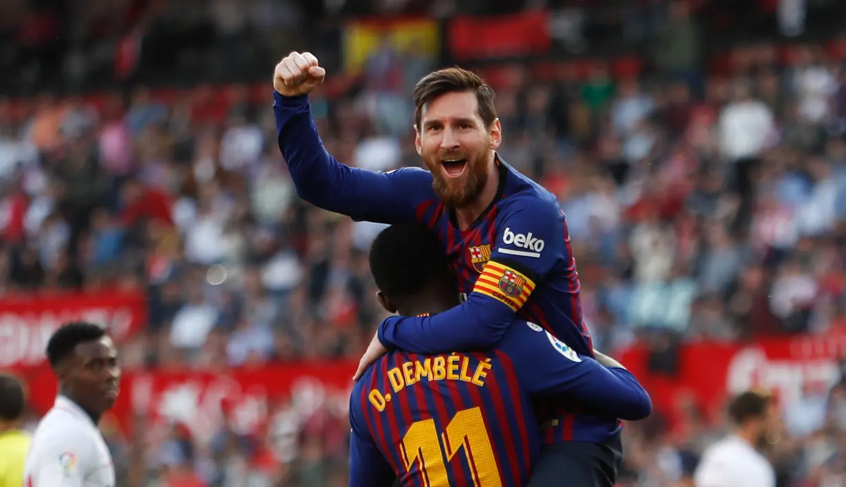 Penyerang Barcelona Lionel Messi memeluk rekan setimnya Ousmane Dembele usai mencetak gol ke gawang Sevilla pada laga La Liga di Stadion Ramon Sanchez Pizjuan, Sevilla, Sabtu (23/2). Barcelona menang 4-2. (AP Photo/Miguel Morenatti)