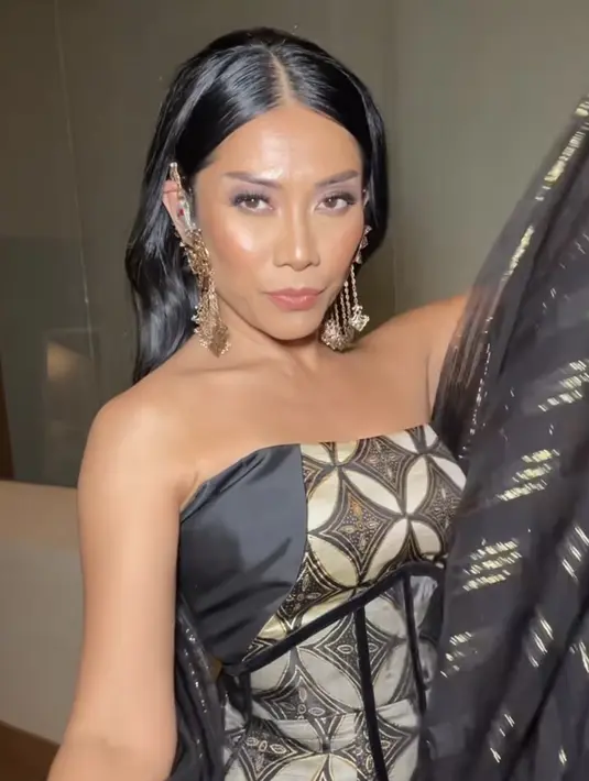 Anggun tampil menawan dibalut gaun batik off shoulder warna hitam keemasan dari fashion designer Ansoe. [@anggun_cipta]