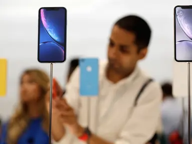 Seorang pengunjung melihat produk baru iPhone saat peluncuran produk baru Apple di Apple Headquarters, Cupertino, California (12/9). Apple merilis tiga iPhone terbaru, yaitu iPhone XS, iPhone XS Max dan iPhone XR. (AP Photo/Marcio Jose Sanchez)