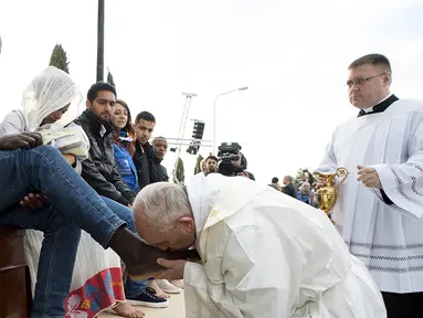 Paus Fransiskus mencium kaki imigran sebelum memimpin misa Kamis Putih, di sebuah lokasi penampungan di Castelnuovo, dekat Roma, Italia, Kamis (24/3/2016). (Reuters/ Osservatore Romano)