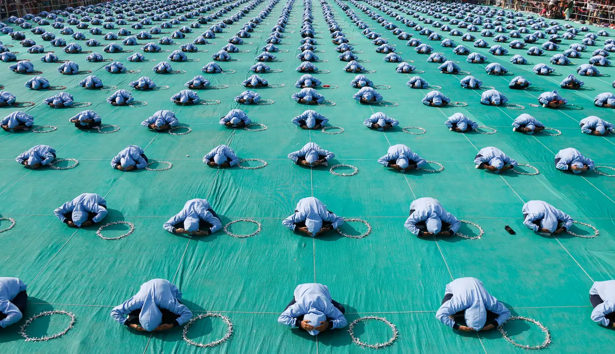 Anak-anak sekolah India menampilkan yoga saat peresmian festival layang-layang Internasional di Ahmadabad, India (7/1). Festival bertaraf internasional ini digelar setiap tahunnya di India. (AP Photo/Ajit Solanki)