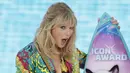 Ekspresi Taylor Swift saat menerima penghargaan Icon Award selama FOX's Teen Choice Awards 2019 di Hermosa Beach, California (11/8/2019). Penyanyi 29 tahun ini tampil cantik mengenakan busana keluaran Versace.  (Rich Fury/Getty Images/AFP)