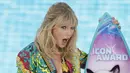 Ekspresi Taylor Swift saat menerima penghargaan Icon Award selama FOX's Teen Choice Awards 2019 di Hermosa Beach, California (11/8/2019). Penyanyi 29 tahun ini tampil cantik mengenakan busana keluaran Versace.  (Rich Fury/Getty Images/AFP)