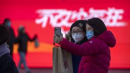 Pengunjung yang mengenakan masker berfoto selfie di pusat perbelanjaan kelas atas pada hari terakhir pekan liburan Tahun Baru Imlek di Beijing, Jumat, 27 Januari 2023. (AP Photo/Mark Schiefelbein)