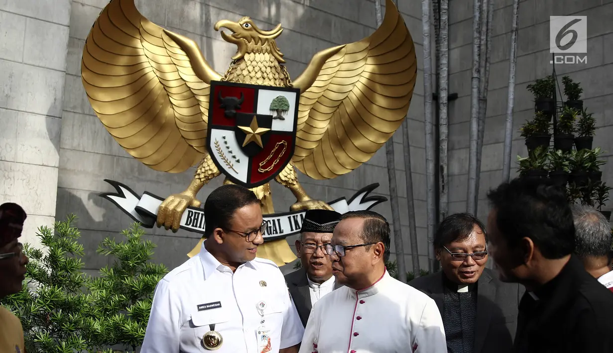Gubernur DKI Jakarta Anies Baswedan berbincang dengan Uskup Agung Jakarta Ignatius Suharyo usai meninjau persiapan dan kelancaran misa malam Natal di Gereja Katedral, Jakarta, Senin (24/12). (Liputan6.com/Herman Zakharia)