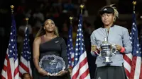 Petenis AS, Serena Williams melihat petenis Jepang, Naomi Osaka saat memegang trofi turnamen AS Terbuka seusai memenangi partai final di Arthur Ashe Stadium, New York, Sabtu (8/9). Naomi Osaka menang dua set dengan skor 6-2 dan 6-4. (AP/Julio Cortez)