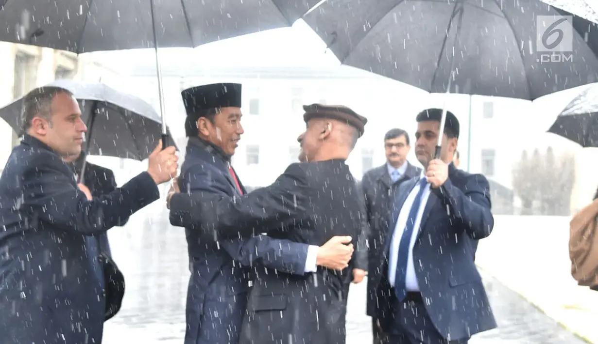 Presiden Afghanistan Ashraf Ghani merangkul Presiden RI Joko Widodo (Jokowi) saat menyambut kedatangannya di tengah hujan salju, dalam kunjungan kenegaraan di Istana Presiden Arg, Kabul, Senin (29/1). (Liputan6.com/Pool/Biro Pers Setpres)