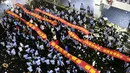 Sejumlah siswa berbaris sambil membentengkan spanduk saat melukan parade untuk menghilangkan stres jelang ujian tahunan "Gaokao" di Haikou, China (4/6). (AFP)