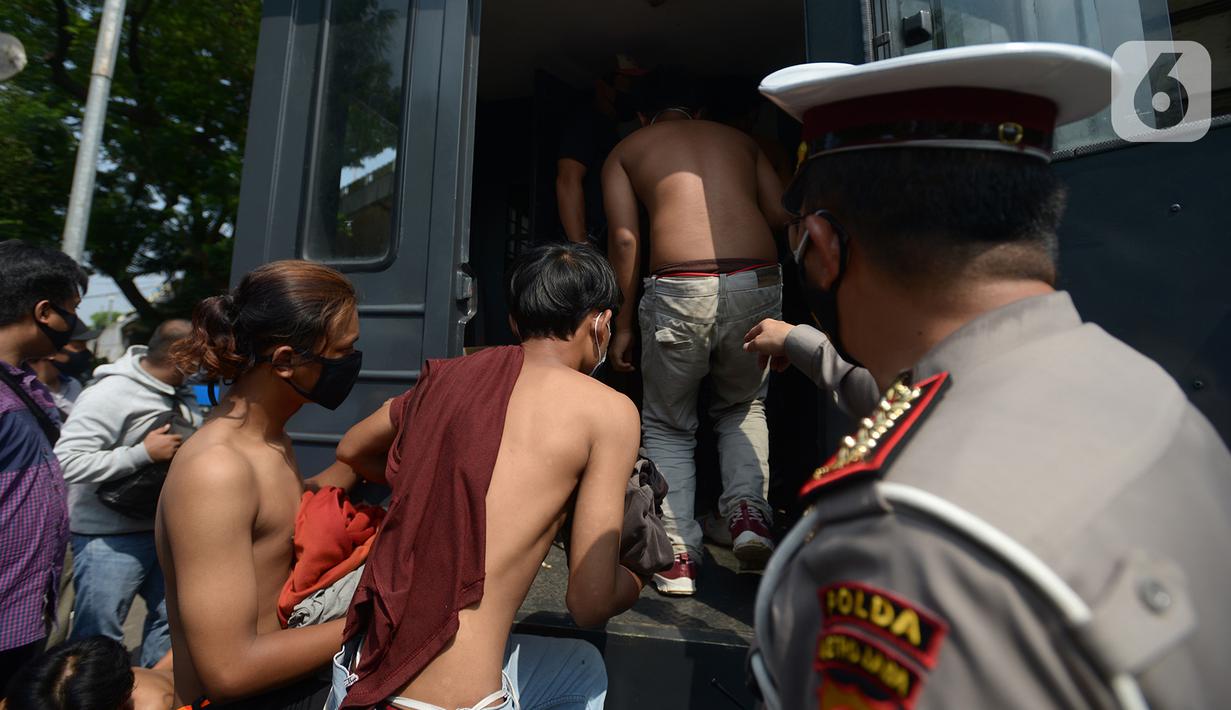 Sejumlah orang menaiki mobil polisi setelah diamankan di Kawasan Senayan, Jakarta, Kamis (8/10/2020). Mereka diduga hendak melakukan unjuk rasa di depan gedung DPR. (merdeka.com/Imam Buhori)