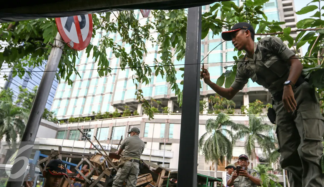 Petugas Satpol PP memutus kabel aliran listrik yang sengaja dibuat oleh PKL untuk penerangan, Jakarta, Selasa (29/3/2016). Puluhan Satpol PP gelar razia PKL liar di kawasan Senen, Jakarta Pusat. (Liputan6.com/Yoppy Renato)