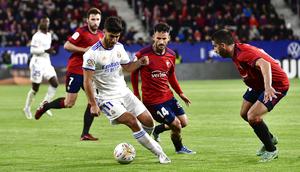 Pemain Real Madrid Marco Asensio (kiri) melindungi bola dari pemain Osasuna Ruben Garcia pada pertandingan sepak bola La Liga Spanyol di Stadion El Sadar, Pamplona, Spanyol, 20 April 2022. Real Madrid menang 3-1. (AP Photo/Alvaro Barrientos)