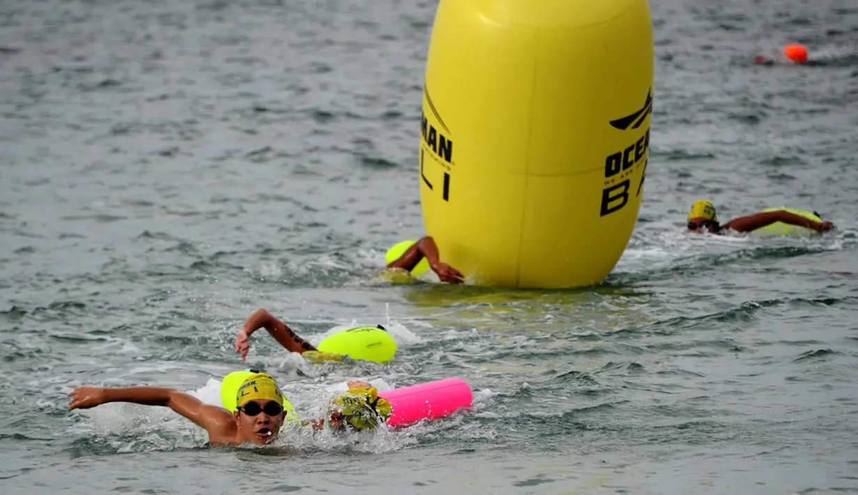 Para peserta bertanding dalam kompetisi renang Oceanman Bali 2021 di sebuah pantai di Sanur, Denpasar, Bali, Sabtu (18/9/2021). Oceanman Bali 2021 diikuti 161 orang peserta. (SONY TUMBELAKA/AFP)
