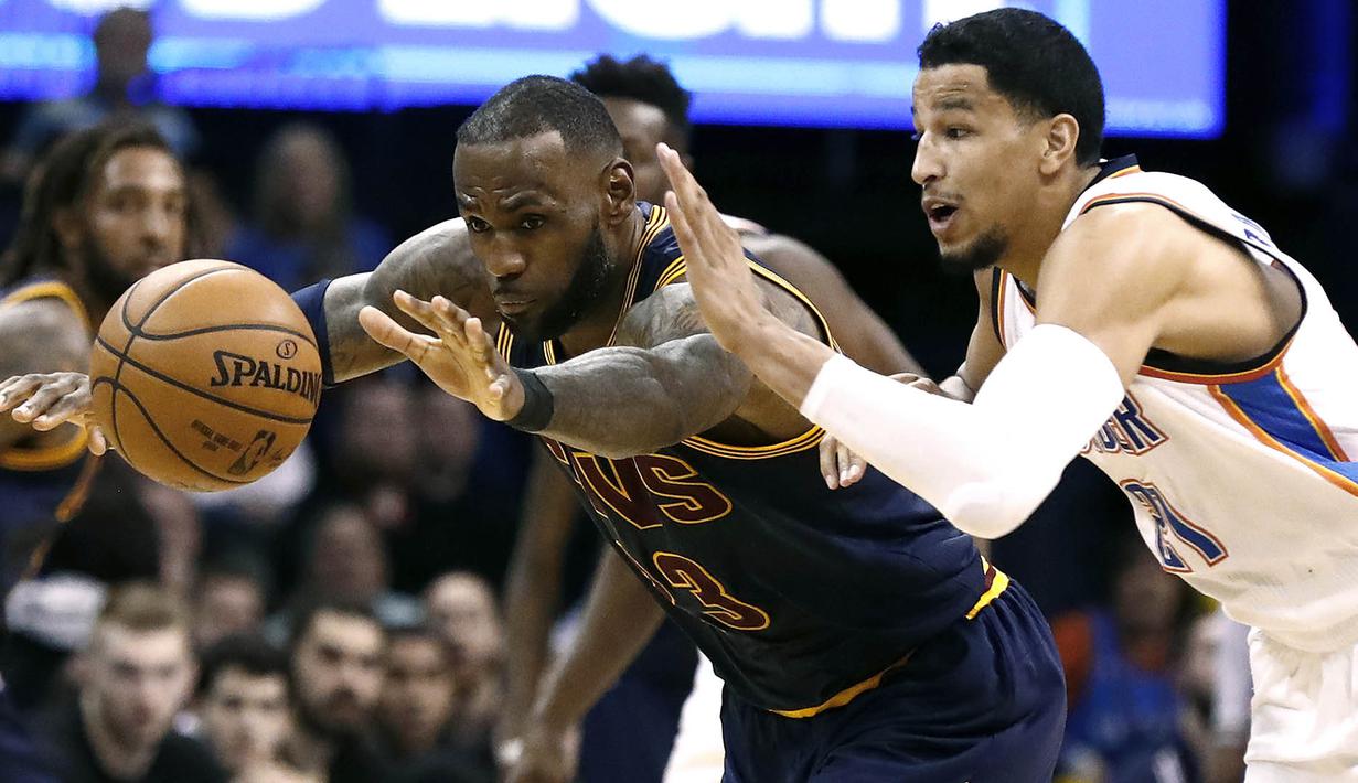 Pebasket Cleveland Cavaliers, LeBron James, berusaha melewati pebasket Oklahoma City Thunder, Andre Roberson. Pada laga ini Cavs kalah 109-118 dari Oklahoma. (EPA/Larry W.Smith)