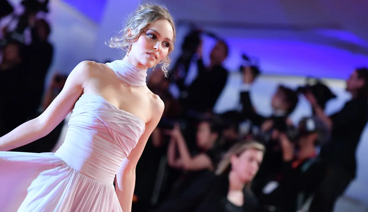 Aktris Lily-Rose Depp berjalan di karpet merah menghadiri pemutaran perdana film 'The King' di Festival Film Venice edisi ke-76, Venice, Italia (2/9/2019). Putri aktor Johnny Depp ini tampil memesona berbalut gaun berwarna pink di karpet merah Venice Film Festival 2019. (AFP Photo/Alberto Pizzoli)