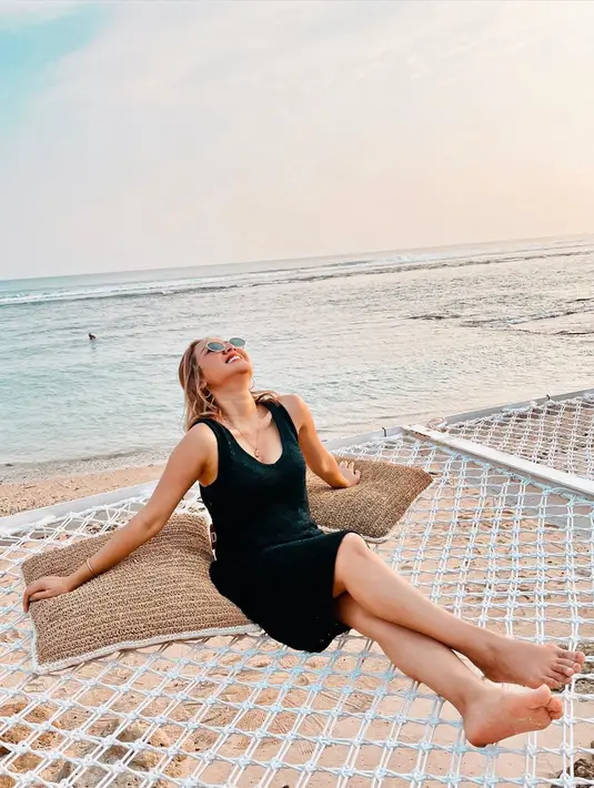 Saat berada di Bali, pelantun tembang Sakitnya Tuh Disini itu tampak bersantai di tepi pantai dengan balutan dress mini berwarna hitam. Pemandangan indah di belakangnya seakan menggambarkan suasana damai dan adem yang ia rasakan. (Liputan6.com/IG/@cita_citata)