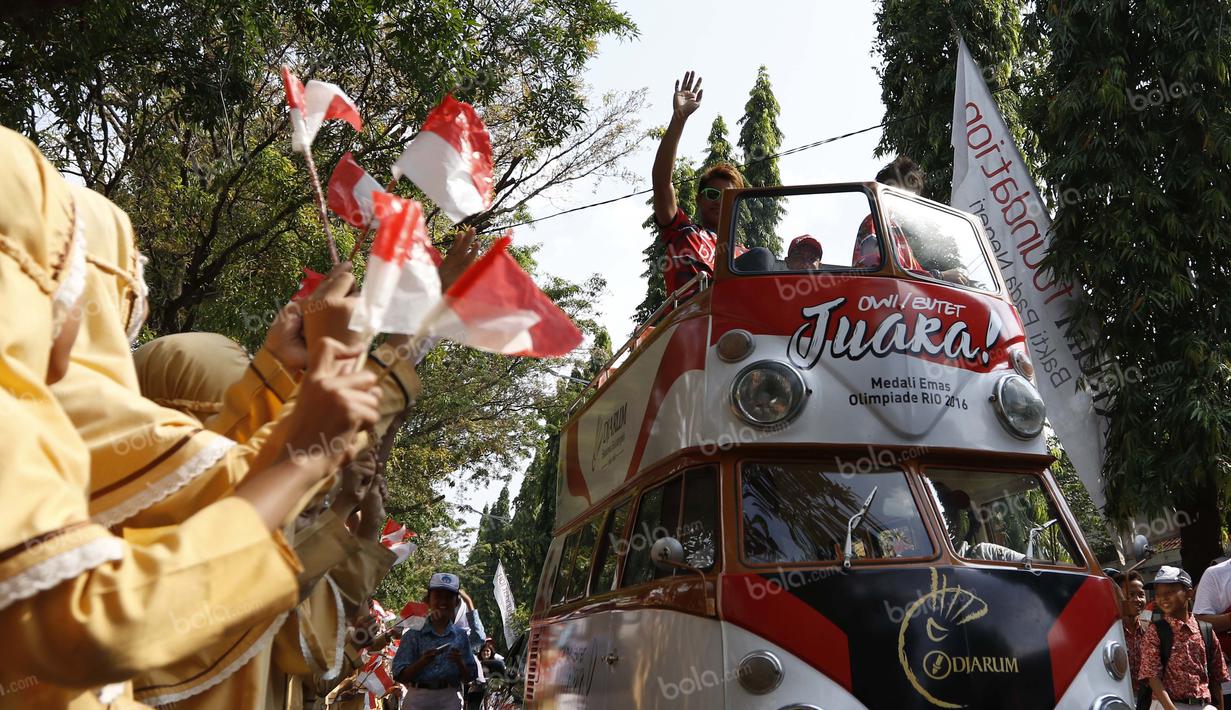 Para siswa sekolah sangat antusia menyambut peraih emas bulutangkis Olimpiade Rio 2016, Tontowi Ahmad dan Liliyana Natsir, saat kirab melewati jalan-jalan utama kota Kudus, Kamis (1/9/2016). (Bola.com/Arief Bagus)