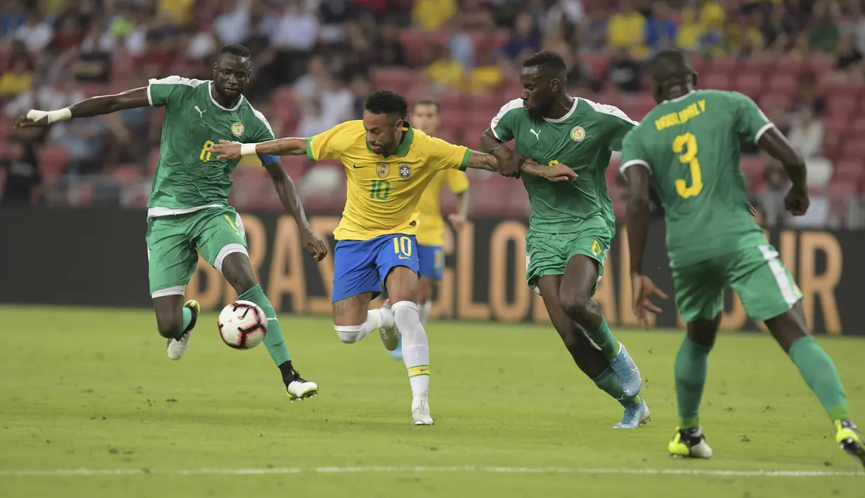 Penyerang Brasil, Neymar berusaha mengontrol bola dari kawalan tiga pemain Senegal pada pertandingan persahabatan di Stadion Nasional di Singapura (10/10/2019). Brasil bermain imbang dengan Senegal 1-1. (AFP Photo/Roslan Rahman)