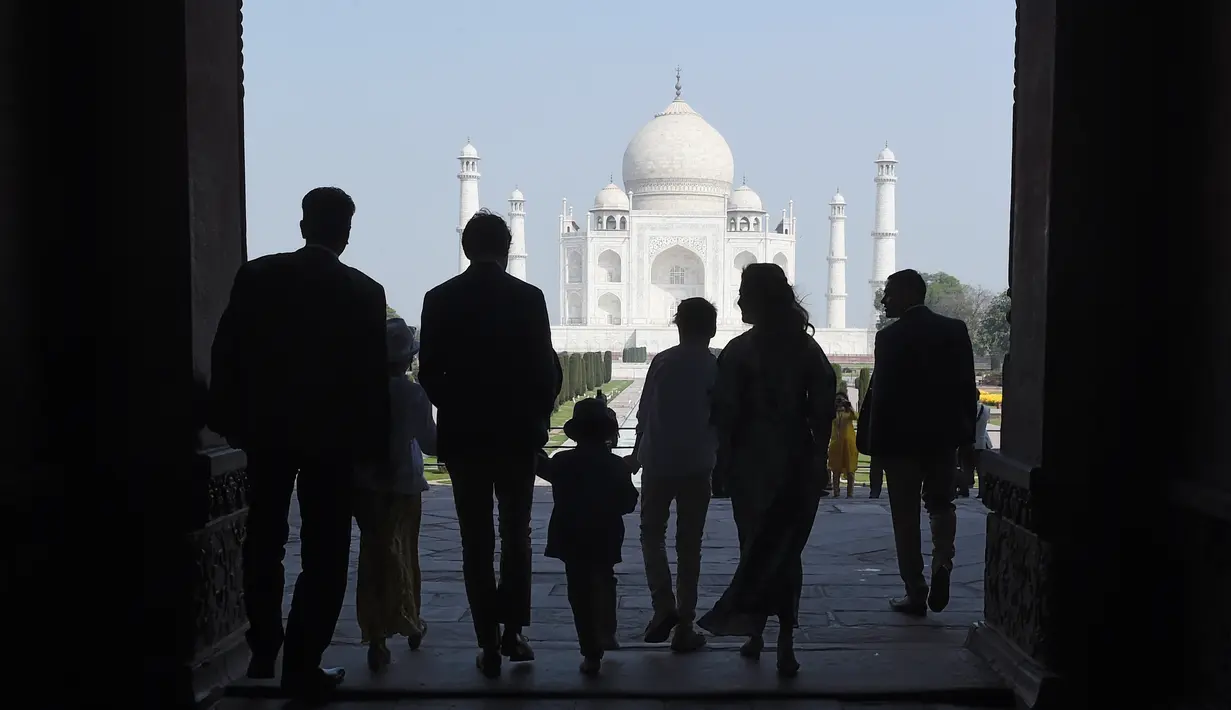 Siluet PM Kanada Justin Trudeau bersama sang istri, Sophie Gregoire Trudeau serta tiga anaknya saat memandangi Taj Mahal di Agra, India, Minggu (18/2). PM Kanada mengajak keluarganya ke Taj Mahal di sela-sela kunjungan ke India. (MONEY SHARMA/AFP)