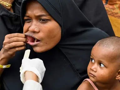 Petugas kesehatan Universitas Syiah Kuala memeriksa seorang pengungsi Rohingya di tempat penampungan sementara gedung pemerintah di Banda Aceh, Aceh, Kamis (11/1/2024). Tim medis dari Rumah Sakit Pendidikan Universitas Syiah Kuala Banda Aceh memberi pelayanan kesehatan rutin bagi pengungsi Rohingya di Banda Aceh. (CHAIDEER MAHYUDDIN/AFP)