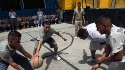 Mantan anggota dua geng sadis, MS-13 dan Barrio 18 bermain basket di Penjara San Francisco Gotera, El Salvador, 16 Juli 2018. (Oscar Rivera/AFP)