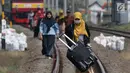 Sejumlah penumpang KRL Commuter Line terpaksa berjalan kaki menuju Stasiun Bojonggede, Bogor, Jawa Barat, Minggu (4/8/2019). Padamnya listrik di wilayah Jabodetabek mengakibatkan perjalanan KRL Commuter Line terhenti. (Liputan6.com/Helmi Fithriansyah)