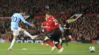 Penyerang Manchester City, Bernardo Silva, mencetak gol ke gawang Manchester United pada laga Premier League di Stadion Old Trafford, Rabu, (24/4). Manchester United takluk 0-2 dari Manchester City. (AP/Jon Super)