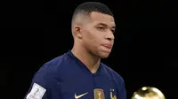 Pemain Prancis Kylian Mbappe berjalan melewati trofi juara dengan membawa trofi penghargaan Sepatu Emas usai melawan Argentina pada pertandingan sepak bola final Piala Dunia 2022 di Stadion Lusail, Lusail, Qatar, 18 Desember 2022. Kylian Mbappe berhak membawa pulang trofi penghargaan Sepatu Emas setelah menjadi pencetak gol terbanyak selama gelaran Piala Dunia 2022. (AP Photo/Martin Meissner)