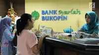 Nasabah melakukan transaksi di Bank Bukopin Syariah, Jakarta, Selasa (30/1). Data OJK yang terekam sampai Oktober 2017 mencatat, pertumbuhan aset perbankan syariah mencapai 19,79% secara tahunan menjadi Rp 395,89 triliun. (Liputan6.com/Angga Yuniar)