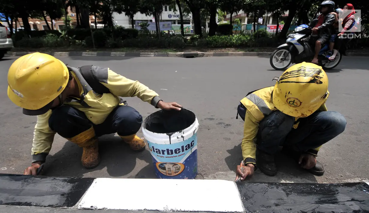Petugas Suku Dinas Bina Marga Jakarta Timur saat menyelesaikan pengecatan trotoar di Jalan Persahabatan Raya, Jakarta, Rabu (27/3). Kegiatan pengecatan ini rutin dilakukan guna merawat sekaligus mempercantik jalur pedestrian tersebut. (merdeka.com/Iqbal S. Nugroho)