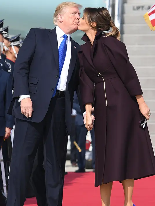 Presiden Donald Trump dan Melania berciuman saat tiba di Pangkalan Udara Osan, Pyeongtaek, Korea Selatan, (7/11). Trump melakukan kunjungan ke lima negara Asia Jepang, Korea Selatan, China, Vietnam dan Filipina. (AP Photo / Andrew Harnik)