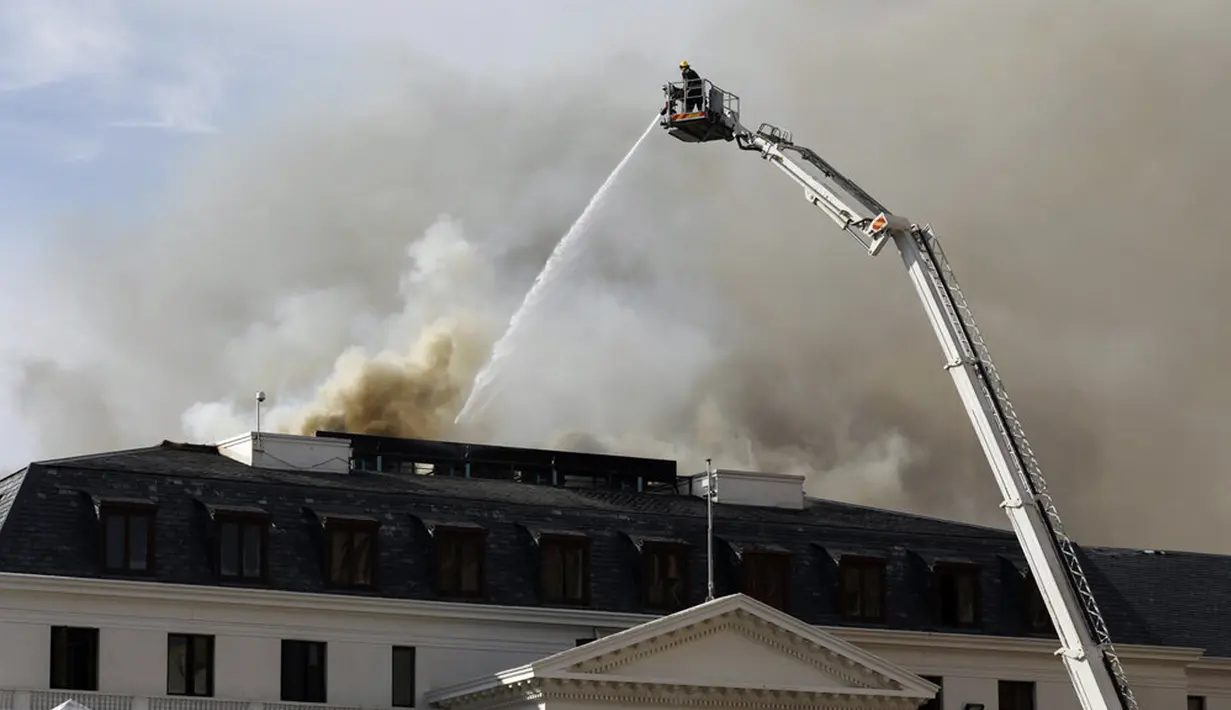Asap mengepul dari Gedung Parlemen di Cape Town, Afrika Selatan, 3 Januari 2022. ​Setelah sempat berhasil dipadamkan, api kembali mengamuk dan membakar Gedung Parlemen Afrika Selatan. (AP Photo/Nardus Engelbrecht)