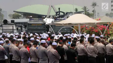 Polisi dan massa aksi 299 melakuan salat Jumat di depan Gedung MPR/DPR, Jakarta, Jumat (29/9). Aksi  tersebut menolak Peraturan Pemerintah Pengganti Undang-Undang Nomor 2 Tahun 2017 tentang Perppu Ormas. (Liputan6.com/Johan Tallo)