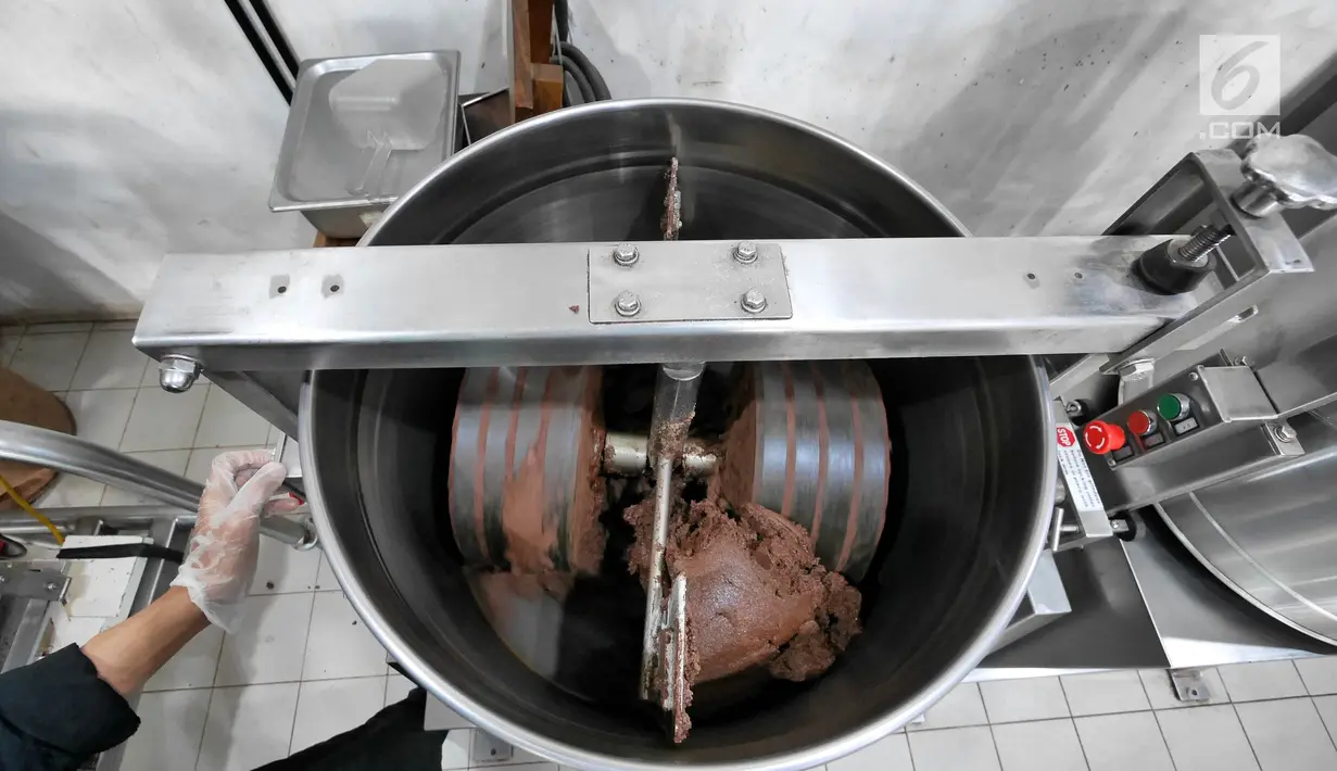 Pekerja mengaduk biji kakao yang sudah digiling di toko Pipiltin Cocoa kawasan Barito, Jakarta, Kamis (13/9). Pipiltin Cocoa memproduksi cokelat dengan biji kako asli Indonesia. (Liputan6.com/Herman Zakharia)