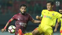 Gelandang PSM Makassar, Zulham M Zamrun (kiri) berebut bola dengan bek Bhayangkara FC, Indra Kahfi pada lanjutan Liga 1 Indonesia di Stadion Patriot Candrabhaga, Bekasi, Kamis (19/10). PSM Makassar unggul 2-0. (Liputan6.com/Helmi Fithriansyah)