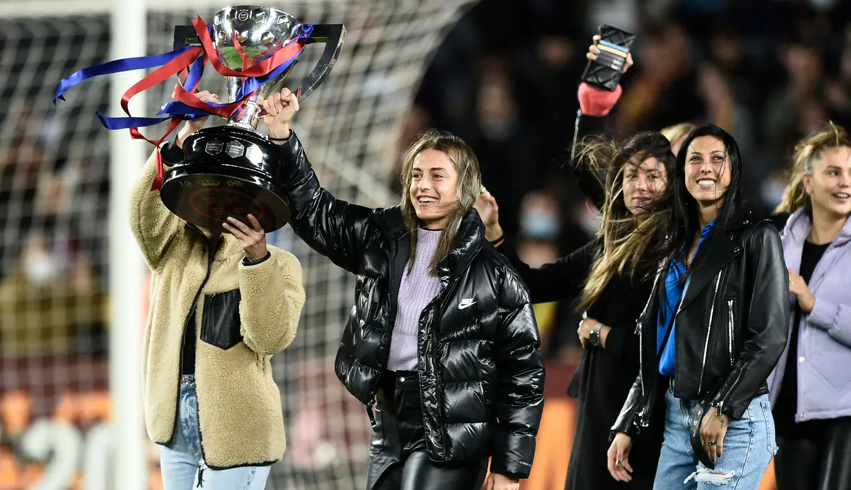 Pemain Barcelona, Alexia Putellas (tengah) merayakan kemenangan bersama rekannya sambil mengangkat trofi Liga Spanyol di Camp Nou, Barcelona 13 Maret 2022. (AFP/Josep Lago)
