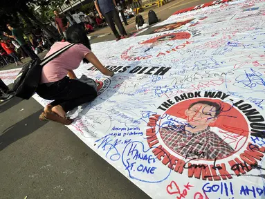 Sejumlah relawan Ahok melakukan aksi tanda tangan sebagai bentuk dukungan menjadi Gubernur DKI di Bundaran HI, Jakarta, Minggu (9/11/2014). (Liputan6.com/Miftahul Hayat)