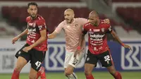 Pemain Persik Youssef Ezzejjari dijaga ketat dua pemain Bali United Willian Pacheco (kiri) dan Leonard Tupamahu  dalam laga pembukaan BRI Liga 1 2021/2022 antara Bali United melawan Persik Kediri di Stadion Utama Gelora Bung Karno, Jumat (27/8/2021). (Foto: Bola.com/Ikhwan Yanuar)