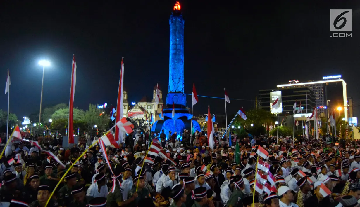 Sejumlah jemaah berkumpul memenuhi jalan sembari mengibarkan bendera merah putih di kawasan Tugu Muda Semarang, Senin (14/8). Mereka hadir mengikuti kegiatan Tausiyah Kebangsaan dalam rangka perayaan HUT ke-72 kemerdekaan RI. (Liputan6.com/Gholib)