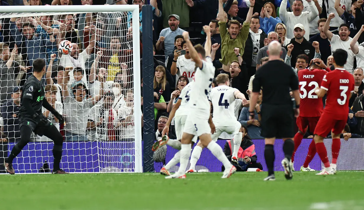 Kiper Liverpool, Alisson Becker, hanya mampu memandangi bola yang masuk ke gawangnya saat melawan Tottenham Hotspur pada laga pekan ketujuh Premier League 2023/2024 di Tottenham Hotspur Stadium, Sabtu (30/09/2023). (AFP/Henry Nicholls)