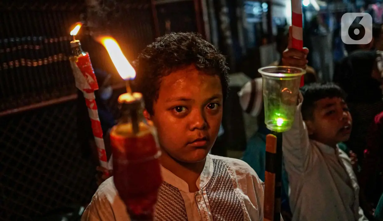 Anak-anak mengikuti pawai obor menyambut Ramadan di kawasan Matraman Dalam, Jakarta, Minggu (27/3/2022). Pawai obor tersebut juga digelar untuk meningkatkan silaturahmi dan ukhuwah sesama umat Muslim serta menyemarakkan syiar Islam di Ibu Kota. (Liputan6.com/Faizal Fanani)