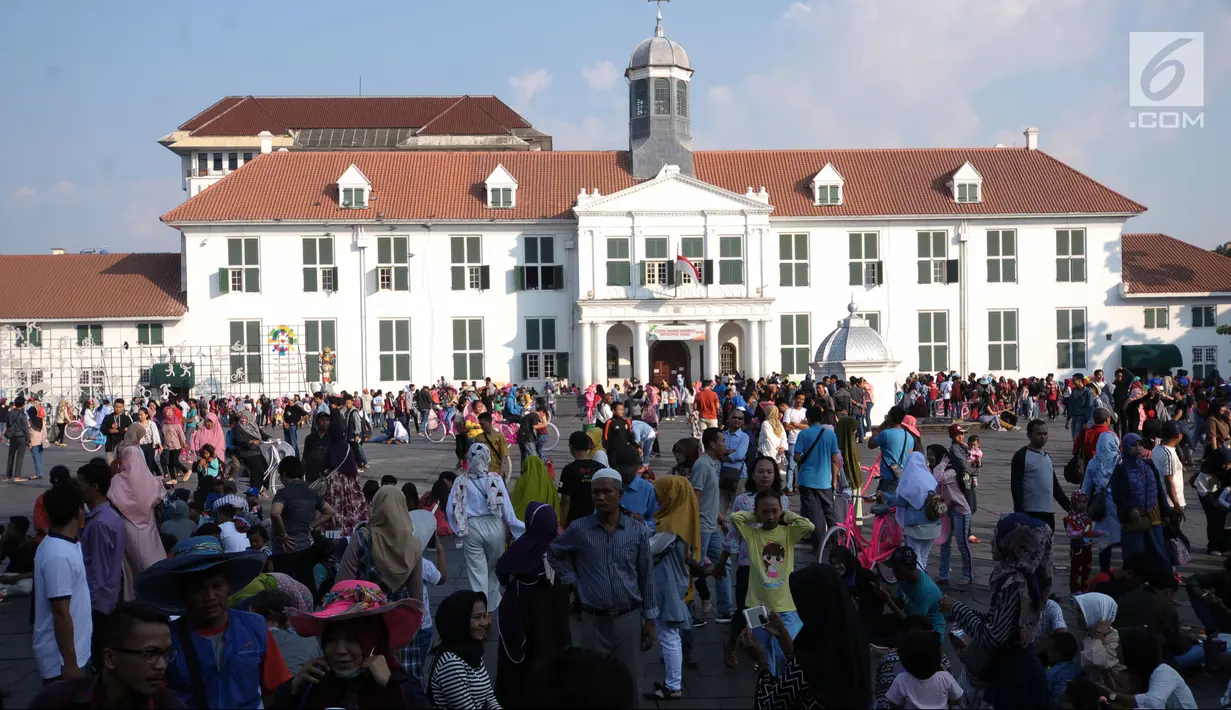 Warga memadati kawasan pelataran Museum Fatahillah, Jakarta, Selasa (19/6). Kemudahan transportasi dan biaya yang murah menjadikan kawasan ini sebagai lokasi favorit warga untuk menghabiskan waktu libur. (Liputan6.com/Helmi Fithriansyah)